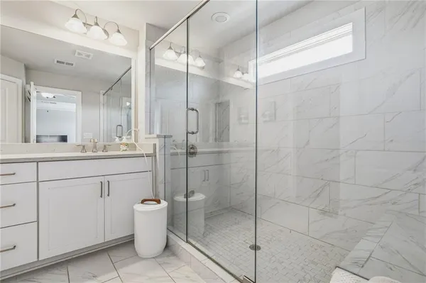 a bathroom with a shower sink vanity and mirror