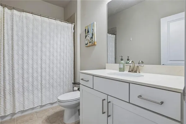 a bathroom with a sink a toilet and shower curtain