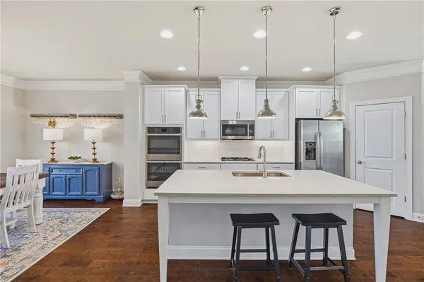 a large kitchen with kitchen island a dining table and chairs