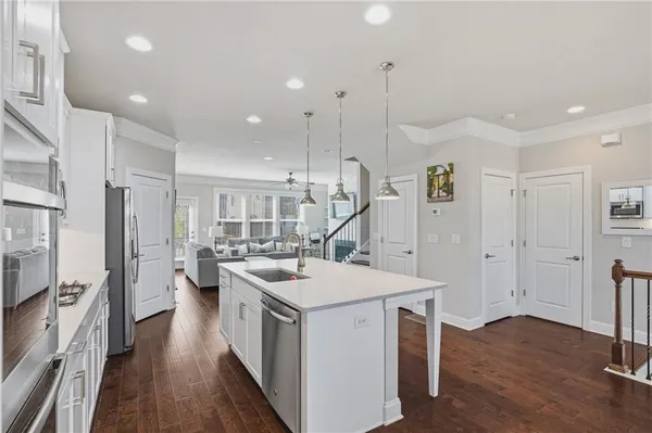a kitchen with a sink appliances and wooden floor