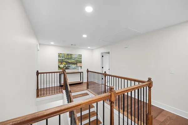 a view of staircase with wooden floor and white walls