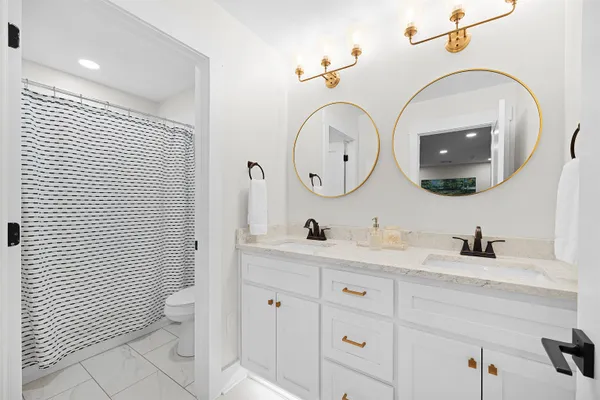 a bathroom with a toilet a sink and mirror