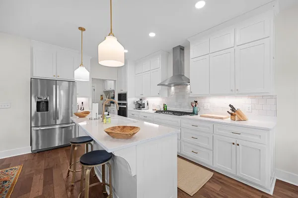 a kitchen with white cabinets and stainless steel appliances