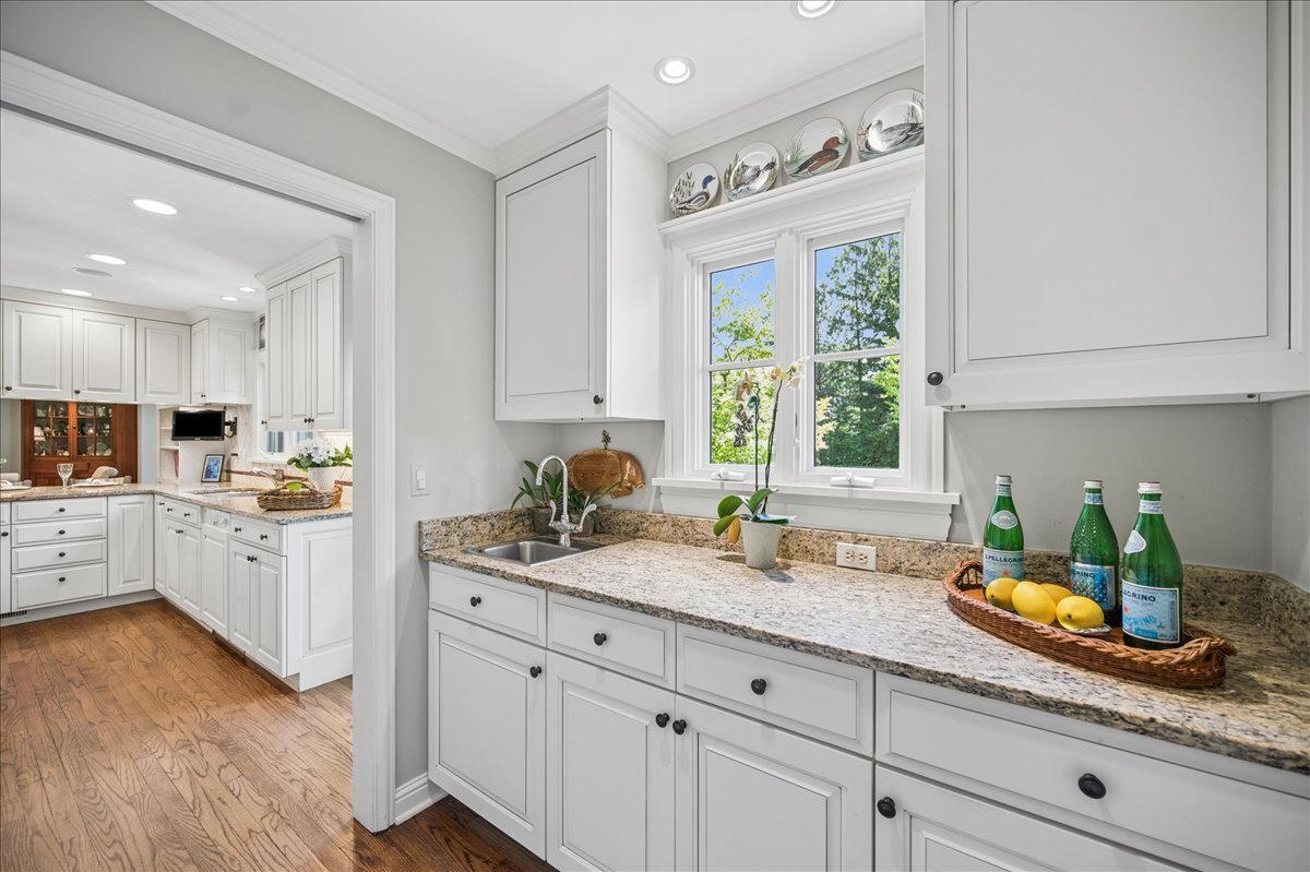 253 Summerfield Road Northbrook, IL 60062 - Photo 22 of 46 a kitchen with granite countertop white cabinets white appliances a sink and a window