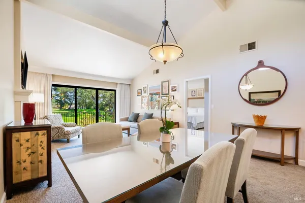 a view of a dining room with furniture a chandelier and a large window