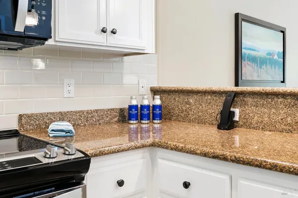 a kitchen with granite countertop a sink and a stove