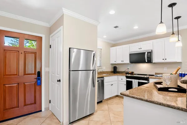 a kitchen with stainless steel appliances granite countertop a refrigerator a stove a sink and a microwave