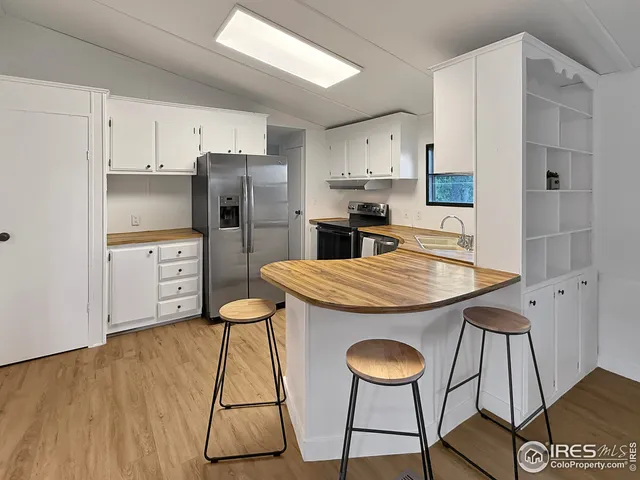 a kitchen with stainless steel appliances granite countertop a table chairs stove and refrigerator