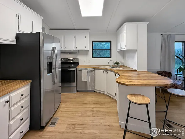 a kitchen with stainless steel appliances a stove a sink refrigerator and a cabinets