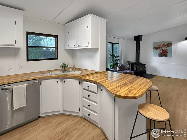 a kitchen with a stove a refrigerator and a sink with wooden floor