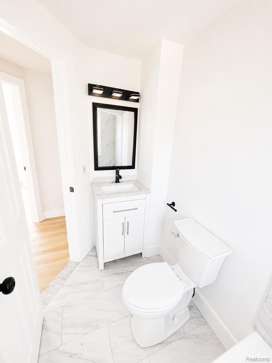 20024 Meyers Road Detroit, MI 48235 - Photo 13 of 16 White vanity with a light-toned countertop, rectangular undermount sink, and matte black faucet