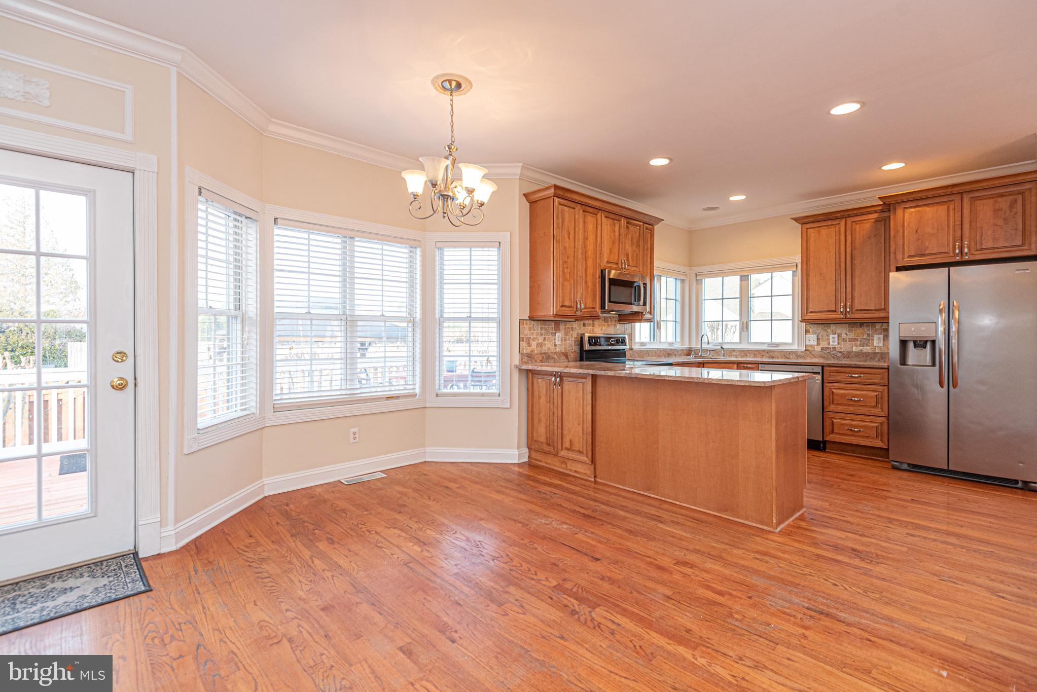 12004 Turtle Mill Road Bishopville, MD 21813 - Photo 28 of 69 a kitchen with stainless steel appliances granite countertop a refrigerator a sink dishwasher a stove and white countertops with wooden floor