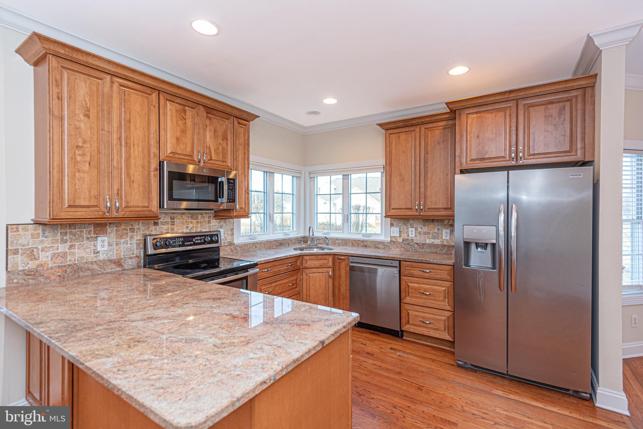 12004 Turtle Mill Road Bishopville, MD 21813 - Photo 29 of 69 a kitchen with stainless steel appliances granite countertop a refrigerator a stove top oven a sink and dishwasher with wooden floor