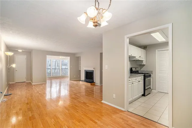 a view of a kitchen with a stove cabinets a ceiling fan and wooden floor