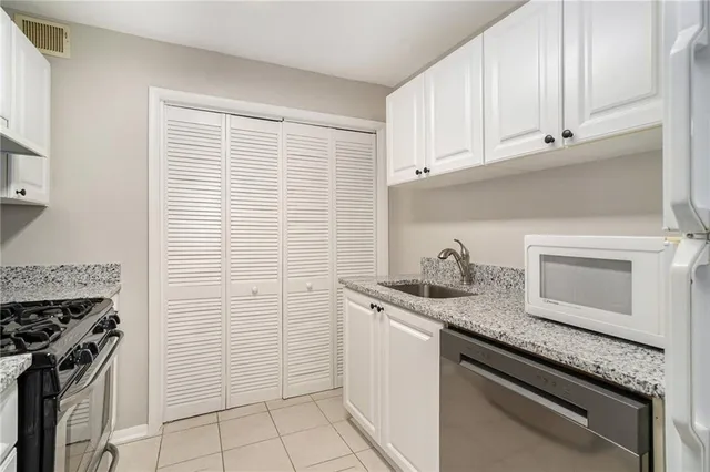 a kitchen with stainless steel appliances granite countertop a sink stove and cabinets