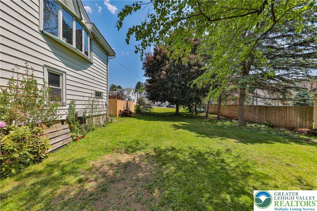 417 3rd Street Lehighton, PA 18235 - Photo 34 of 39 A well-maintained side yard with mature trees and a sturdy wooden fence.