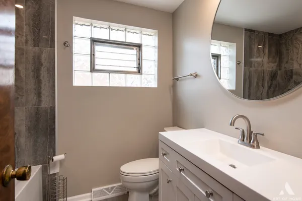 a bathroom with a toilet a sink and mirror