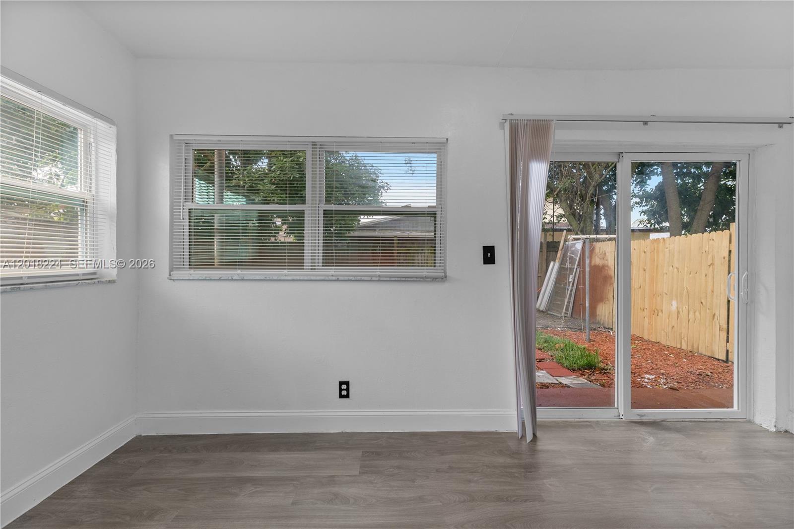 7958 Southwest 6th Street Pompano Beach, FL 33068 - Photo 40 of 57 a view of an empty room with wooden floor and windows