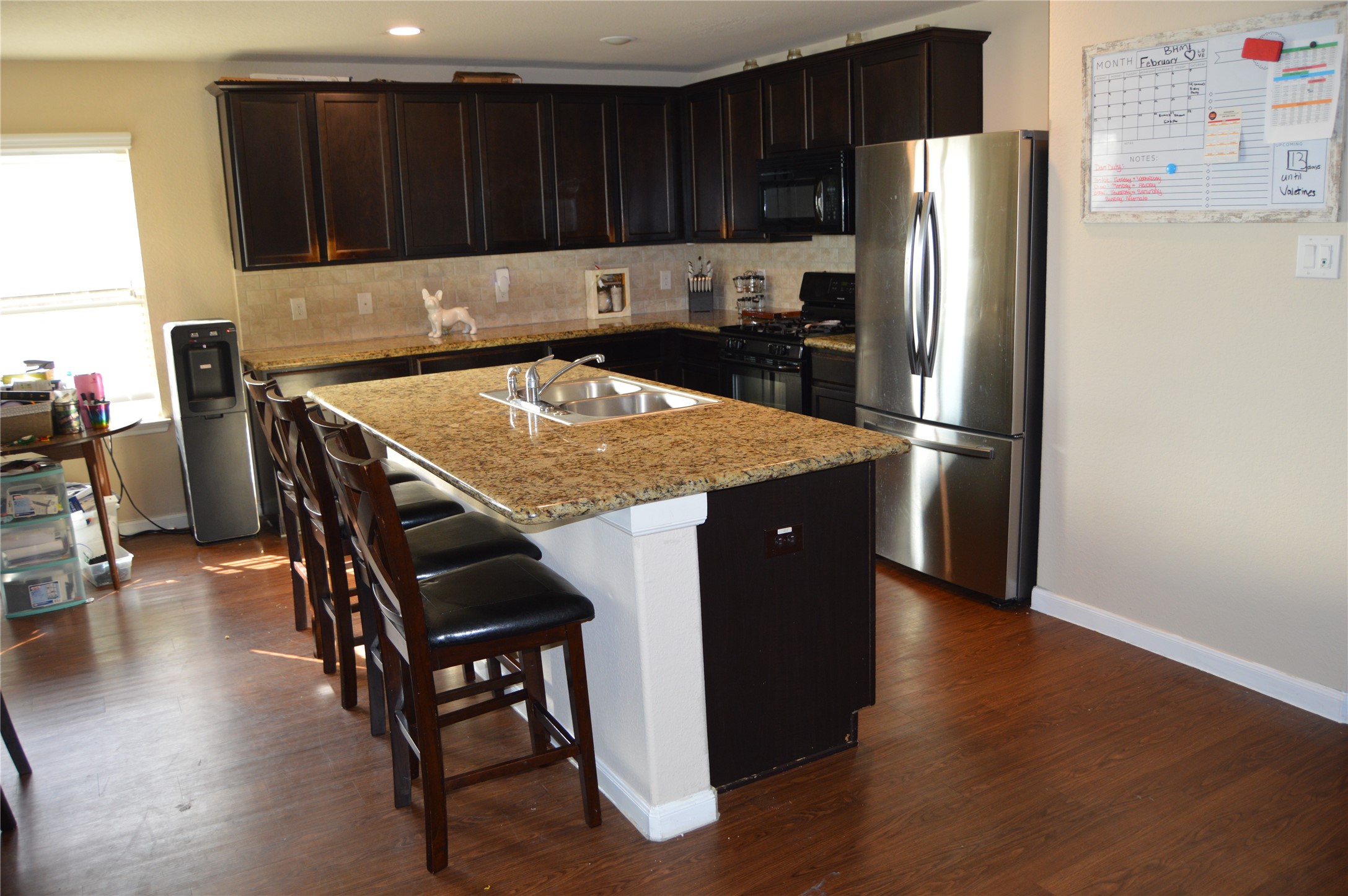 1838 Luminous Waters Lane Rosharon, TX 77583 - Photo 8 of 9 a kitchen with a refrigerator a stove a sink and a dining table with wooden floor