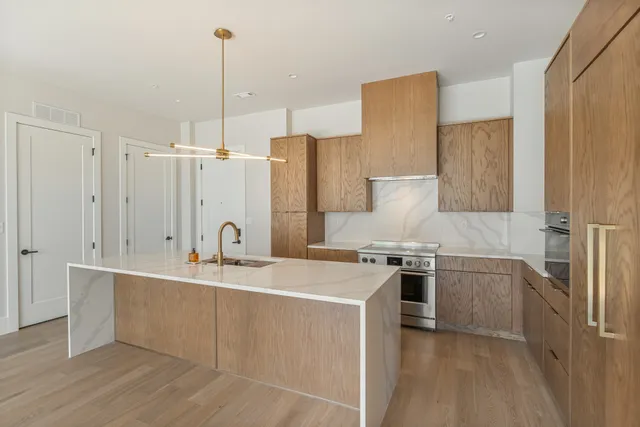 a kitchen with stainless steel appliances granite countertop a sink stove and refrigerator