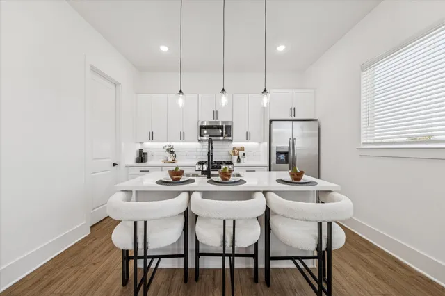 a dining room with furniture a chandelier and wooden floor