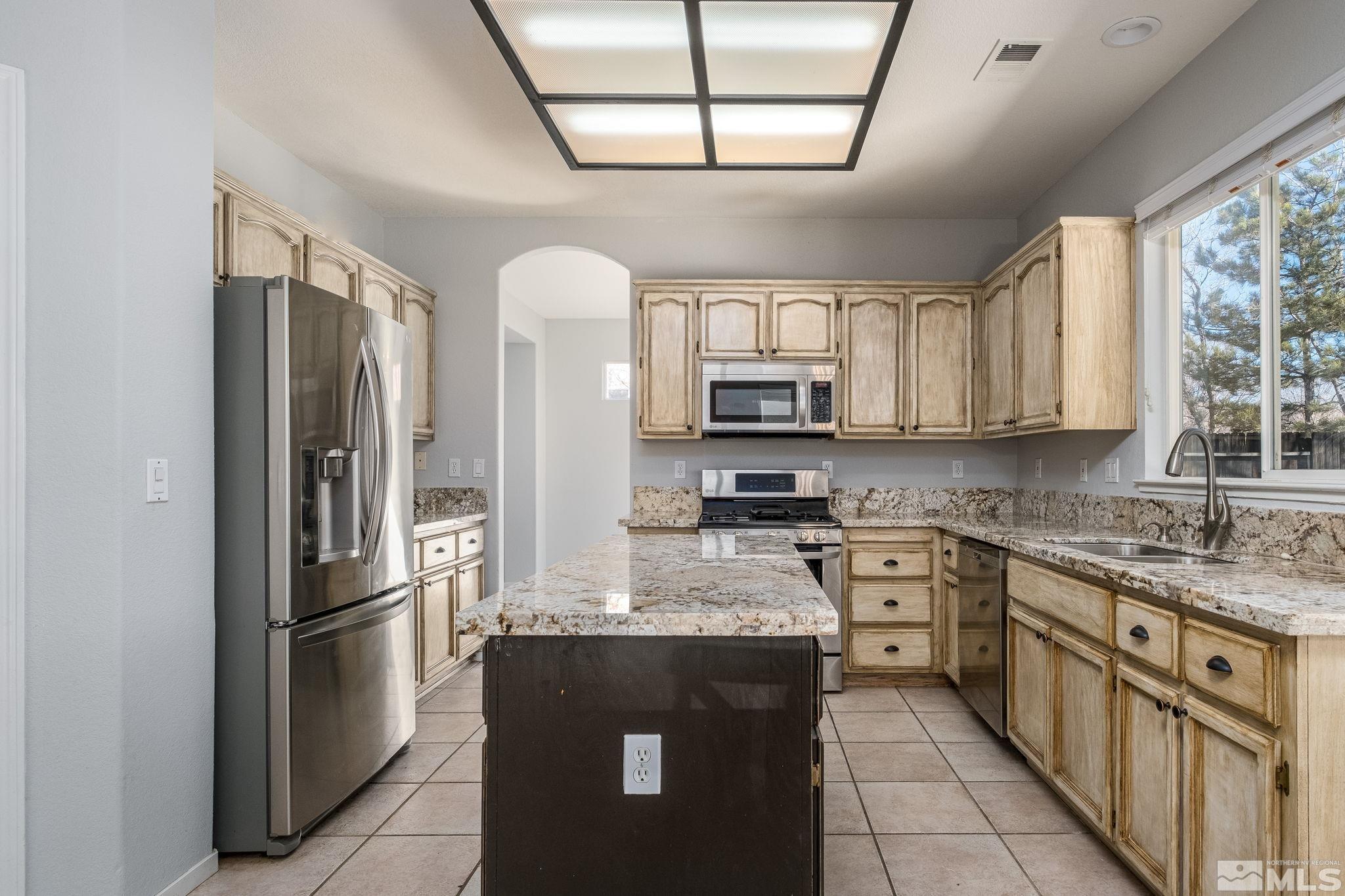 9430 Oakley Lane Reno, NV 89521 - Photo 11 of 28 a kitchen with stainless steel appliances granite countertop a refrigerator a stove a sink and a microwave