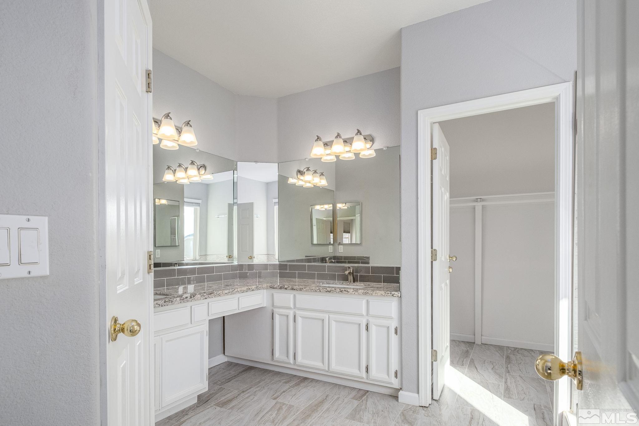 9430 Oakley Lane Reno, NV 89521 - Photo 19 of 28 a bathroom with granite countertop a sink and a mirror