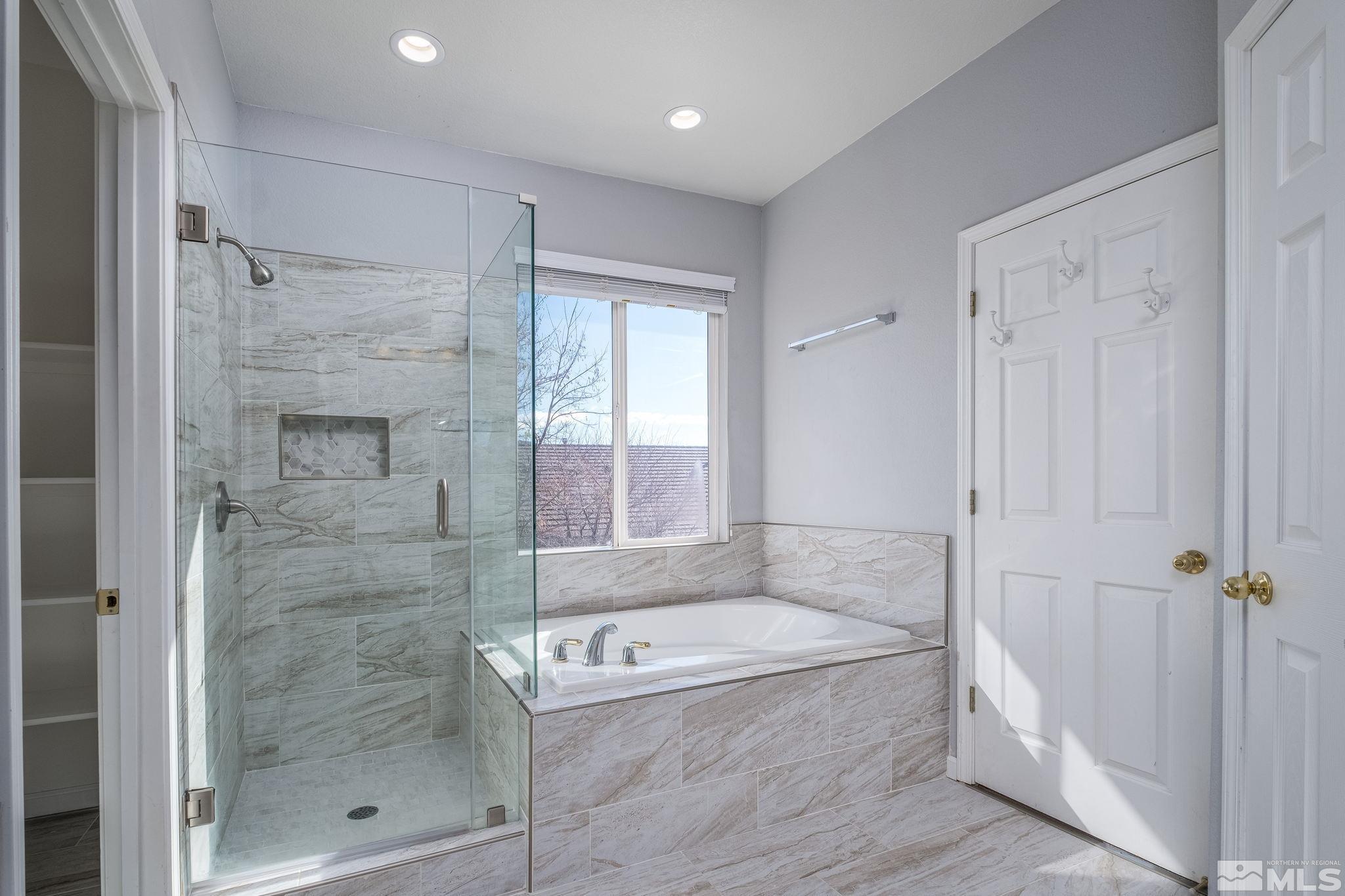 9430 Oakley Lane Reno, NV 89521 - Photo 20 of 28 a bathroom with a granite countertop bathtub shower and vanity