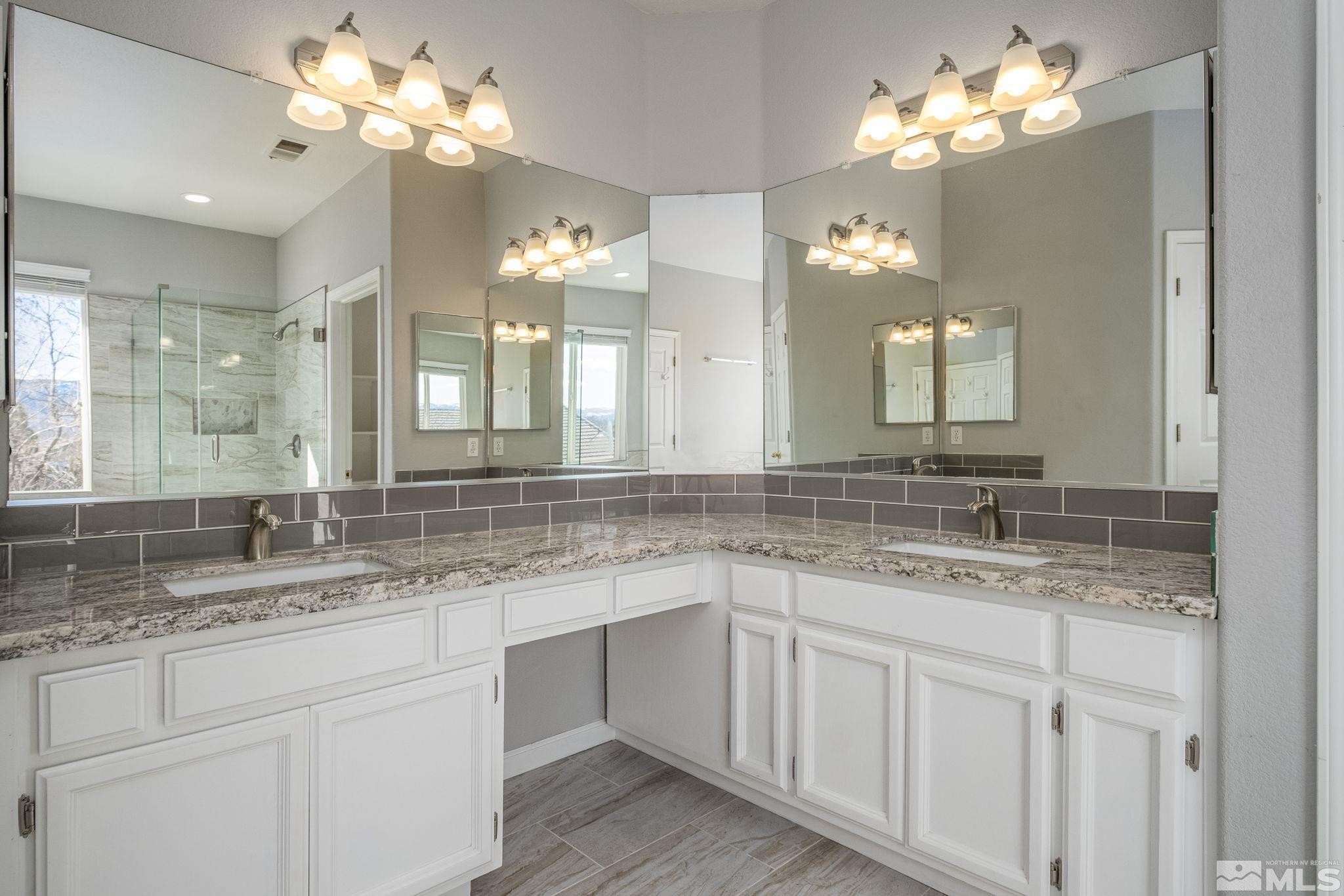 9430 Oakley Lane Reno, NV 89521 - Photo 21 of 28 a bathroom with a granite countertop double vanity sink and a mirror