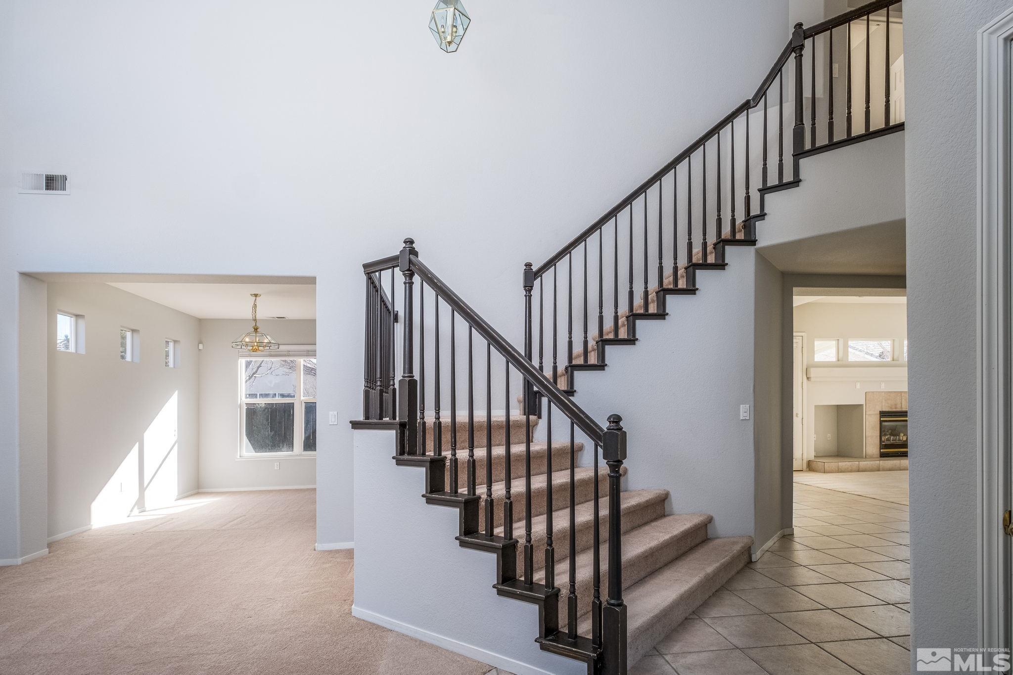 9430 Oakley Lane Reno, NV 89521 - Photo 6 of 28 a view of staircase with lots of frames on wall and a table