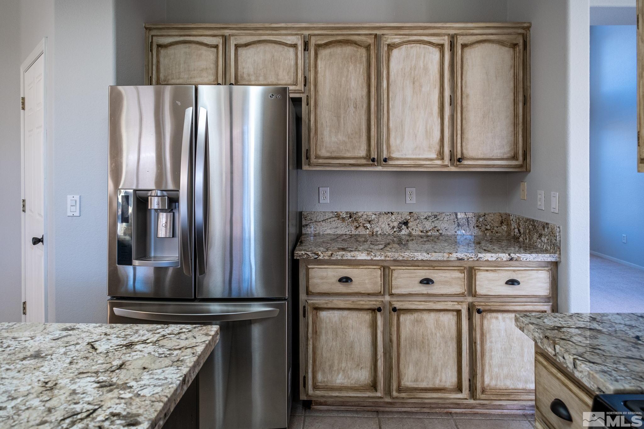 9430 Oakley Lane Reno, NV 89521 - Photo 10 of 28 a kitchen with granite countertop a refrigerator and stove
