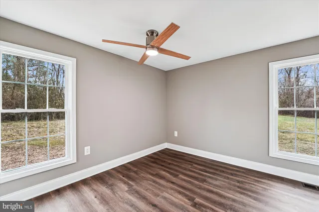 wooden floor in an empty room with a window