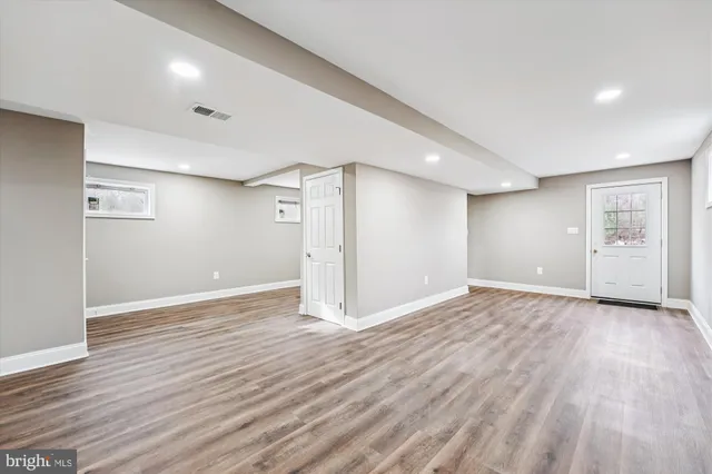 a view of an empty room with wooden floor