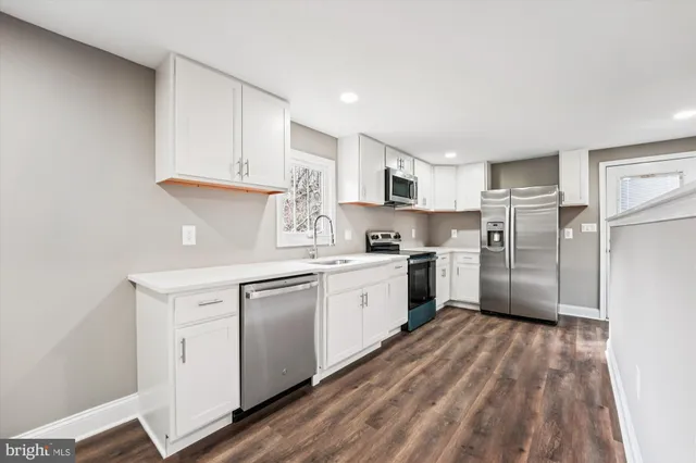 a kitchen with white cabinets and white appliances