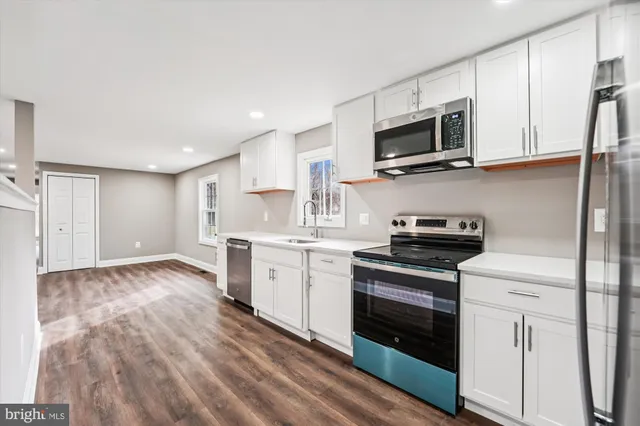 a kitchen with stainless steel appliances granite countertop a stove a sink and a microwave