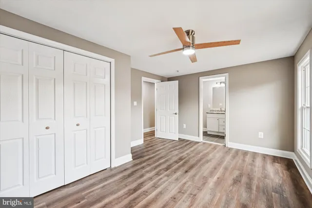 a view of empty room with wooden floor and ceiling fan