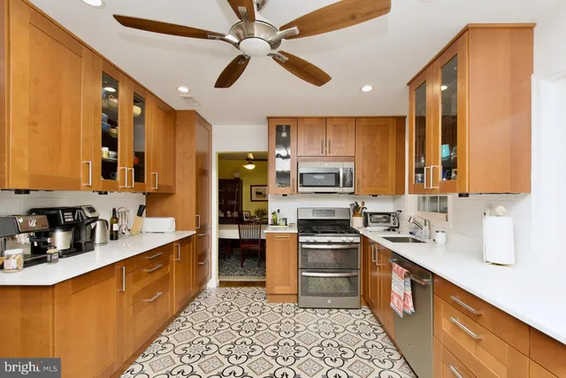 a kitchen with stainless steel appliances a sink cabinets and wooden floor
