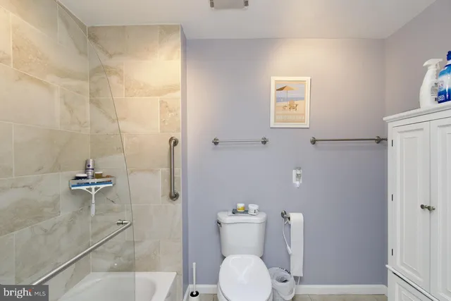 a white toilet sitting next to a bath tub shower