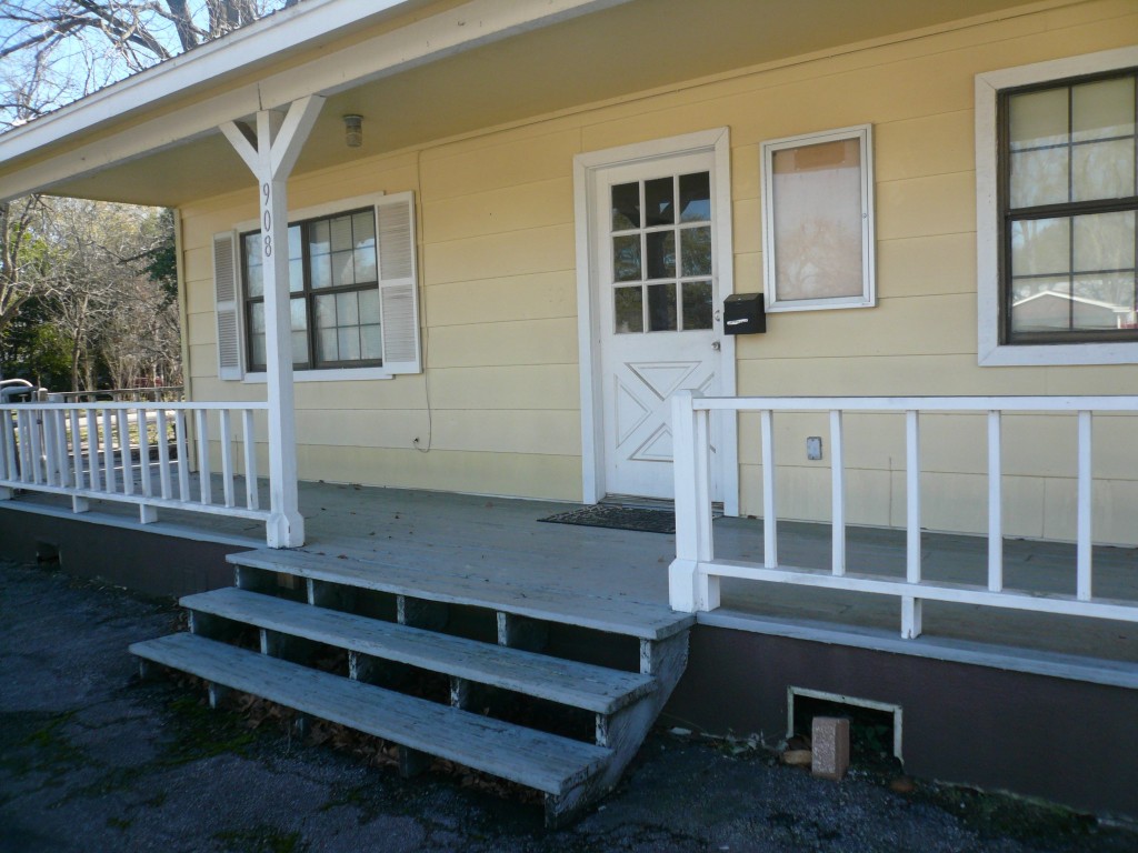 a view of a house with wooden deck front of house