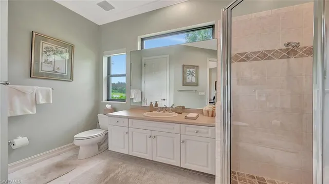 a spacious bathroom with a granite countertop sink a toilet and a mirror