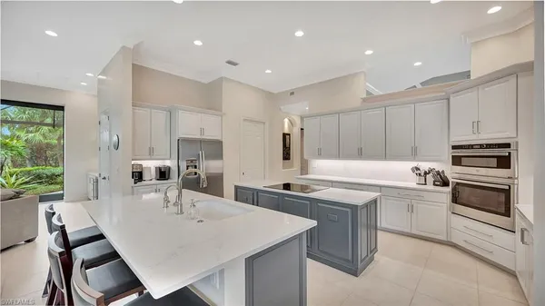 a kitchen with stainless steel appliances kitchen island granite countertop a sink a stove a dining table and chairs