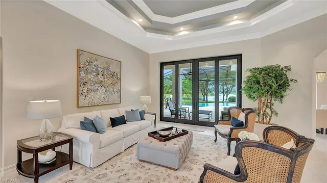 a living room with furniture and a large window with potted plants