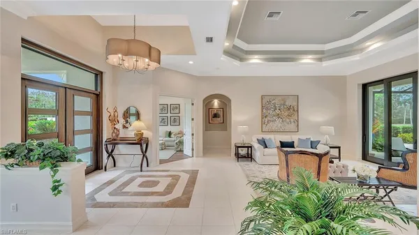 a view of a livingroom with furniture a chandelier and wooden floor