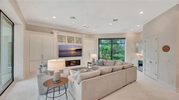 a living room with furniture fireplace and a large window