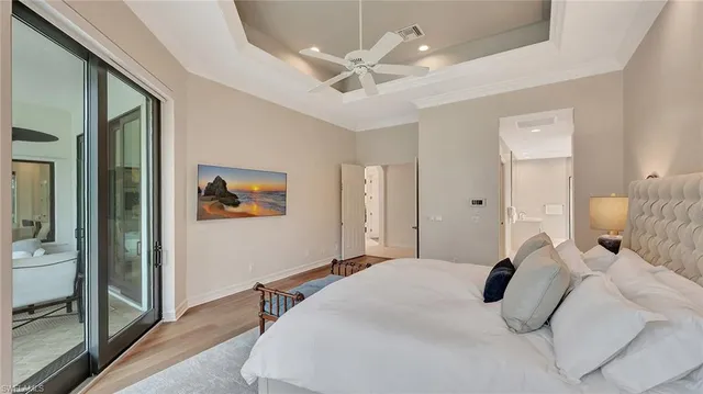 a bedroom with a large bed and a chandelier