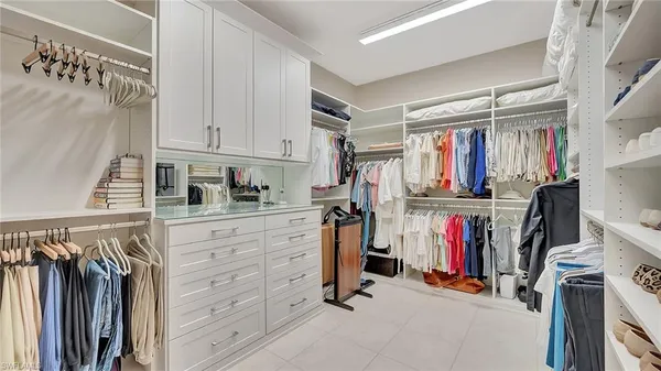 a view of walk in closet with clothes and shoes