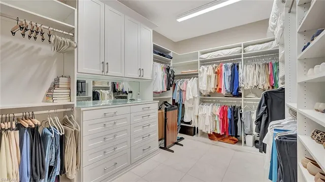 a view of walk in closet with clothes and shoes