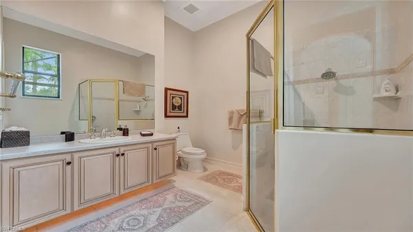 a bathroom with a double vanity sink toilet mirror and shower