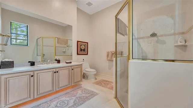 a bathroom with a double vanity sink toilet mirror and shower