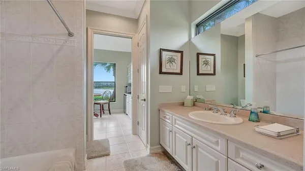 a spacious bathroom with a granite countertop sink a mirror and a bathtub